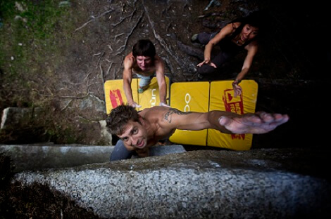 De spotter en het crashpad vangen een val tijdens het boulderen
op